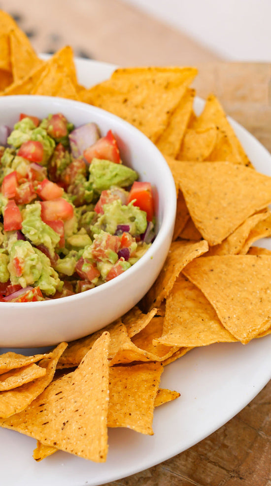 Guacamole recipe from Crimson tavernorlando x Alyssa Marie. Photo features chips surrounding bowl of homemade guacamole.