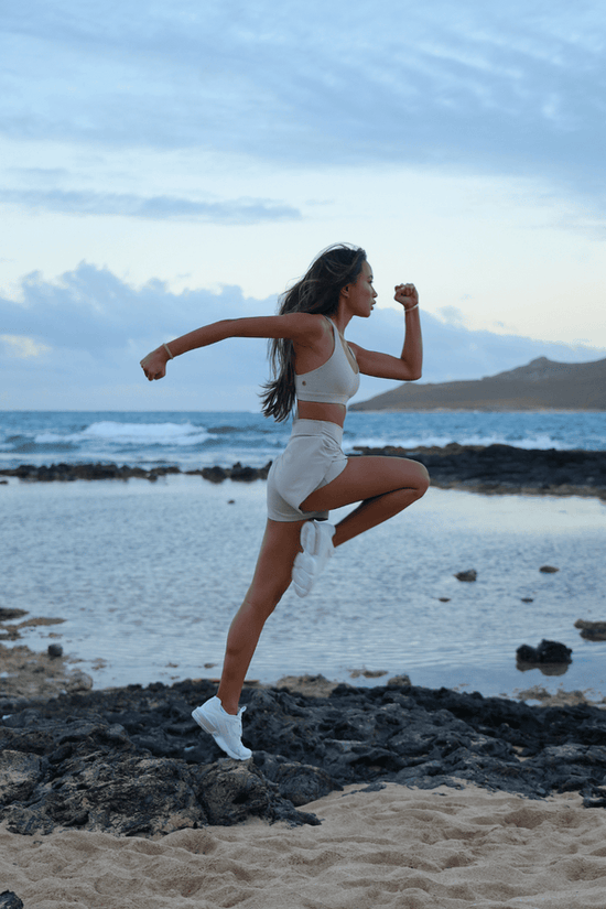 Photograph of model wearing the color Stone in a running position